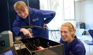 Two researchers showing an optical cavity demonstration unit. 