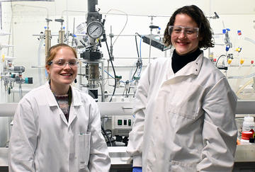 Rosie Thorogood and Dr Katharina Eisenhardt working with their specialist high CO2 pressure set up, fitted with an IR probe that can track diagnostic stretches during the polymerisations.