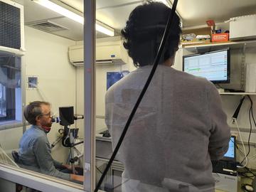 The molecular flow sensor team Man breathing into a molecular flow sensor device.