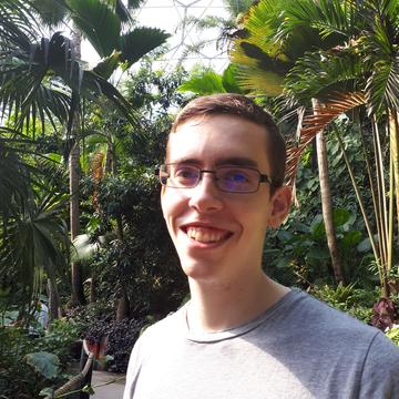 Headshot photograph of Matt Reveley at a tropical greenhouse.